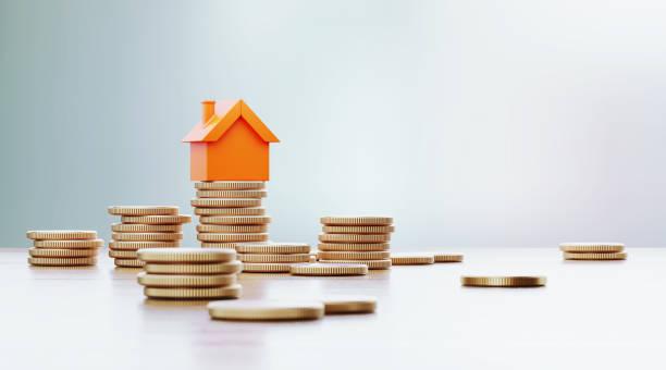 Image of an illustrated house sitting on top of coins