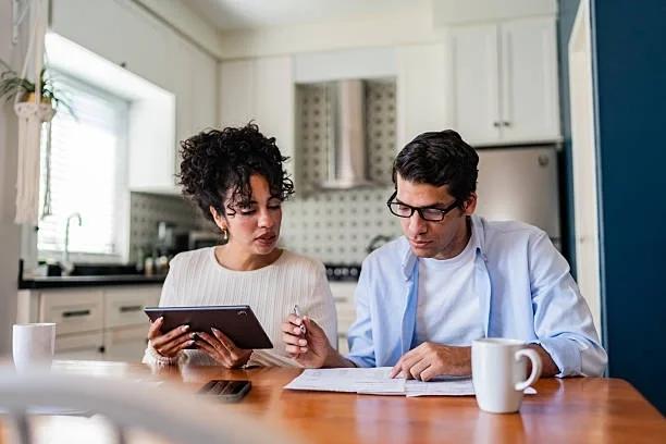 Image of a coupel looking at their budget. Government sets out 5 changes to help with everyday costs ahead of the budget. Ahead of tomorrow’s budget, the government has announced changes for unpaid carers, new parents, people who drive for work and f