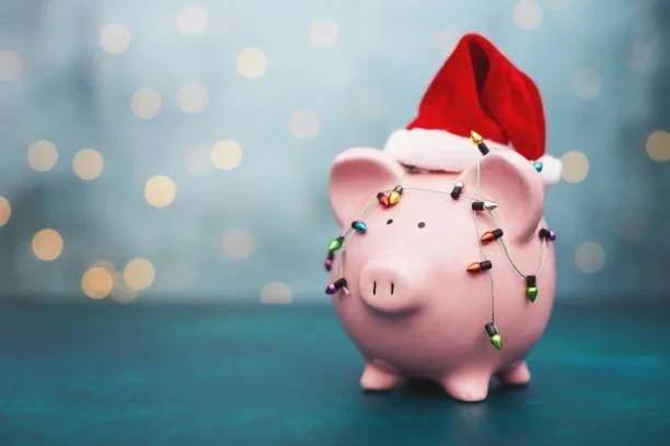 Piggy bank with a Santa hat and Christmas lights wrapped around. 2025 Christmas dates that’ll affect your DWP payments. When your DWP payments will arrive over the festive season