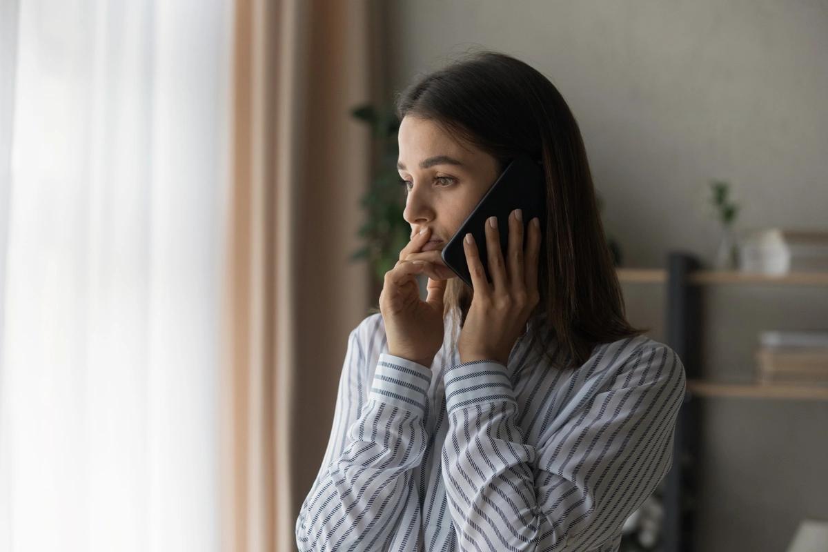 Concerned woman listening on phone call