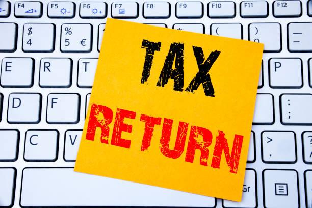Image of a key board with a yellow post-it note on top saying 'tax return' - three days left to submit a self-assessment tax return or face fines - even if you have no tax to pay