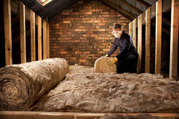 Image of a man installing insultation in a loft