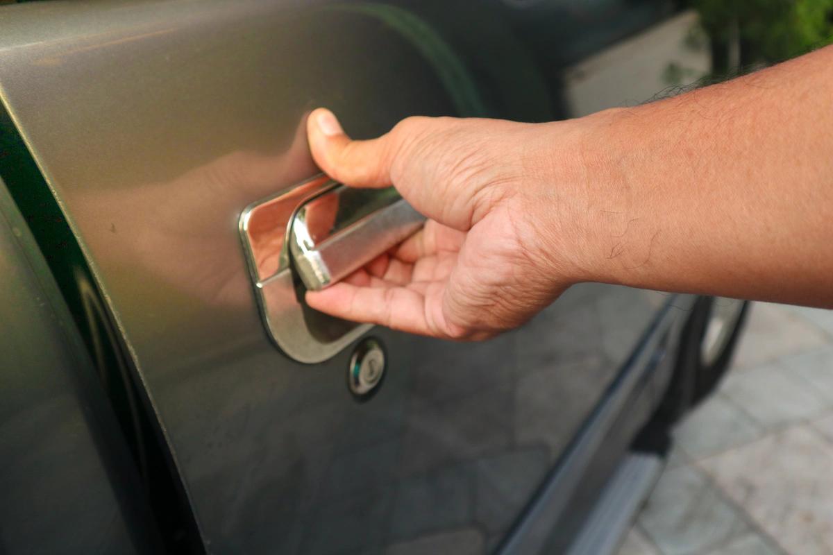 Close up of man's hand opening a car door