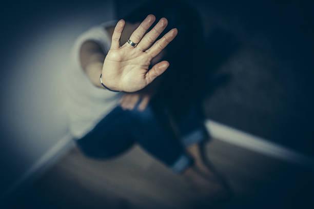 Image of a woman with her hand up to camera blocking abuse