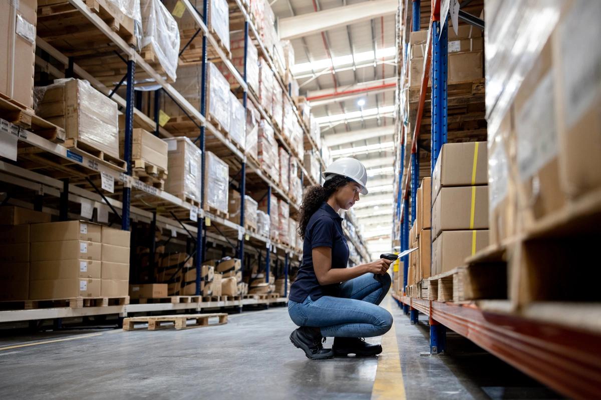 A woman working in a distribution warehouse doing a stocktake