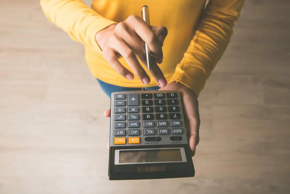 Person typing into calculator
