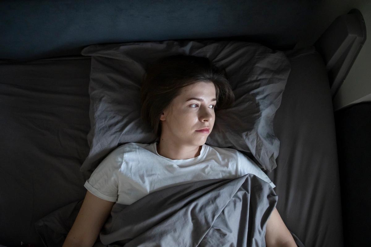 A female care leaver lying in bed living independently in supported housing