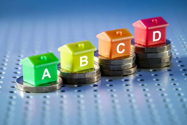 Image of a pile of coins getting higher with monopoly houses on top saying A, B, C, D. Thousands of people exempt from paying council tax or due a discount - find out how to make a saving here