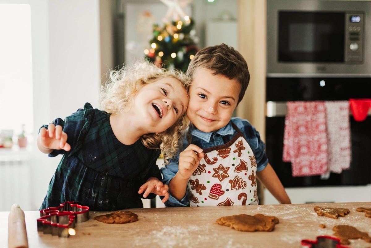 Two young children baking Christmas cookies