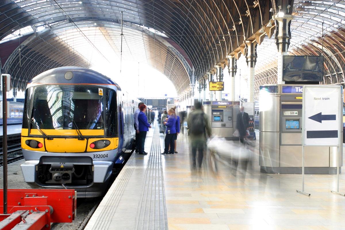 a train idle in a station, with staff chatting on the platform