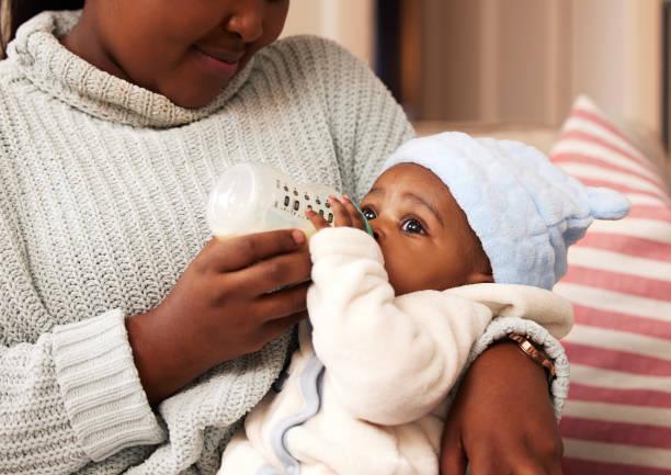 Image of a baby being bottle fed by its mother