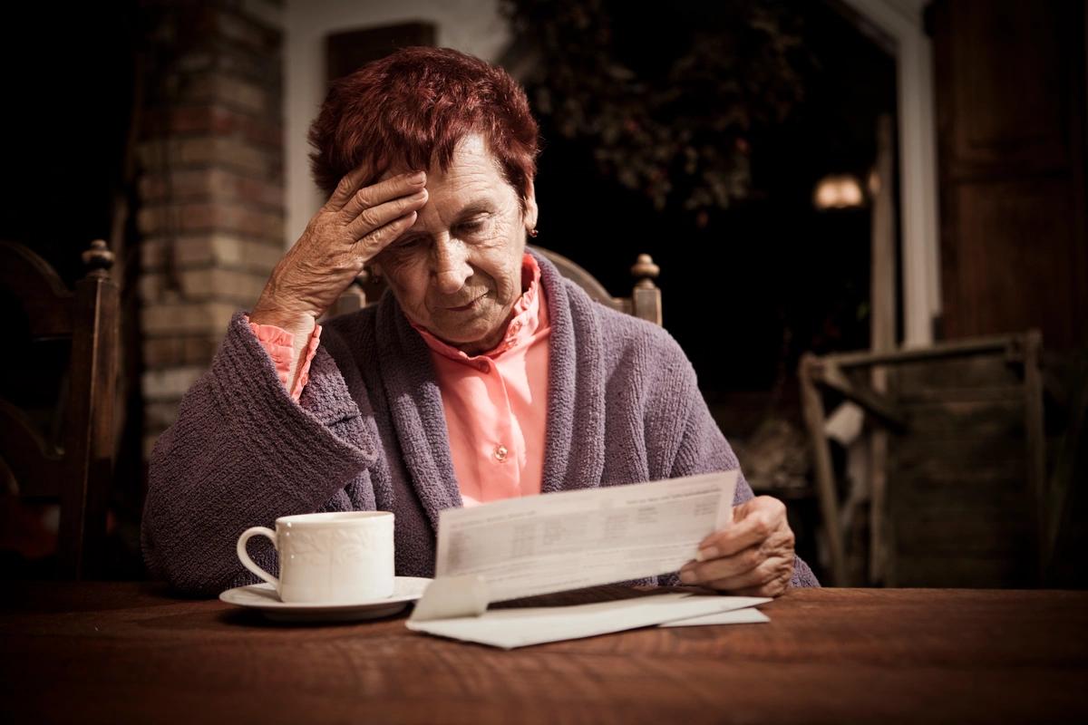 A worried elderly renter goes through her bills