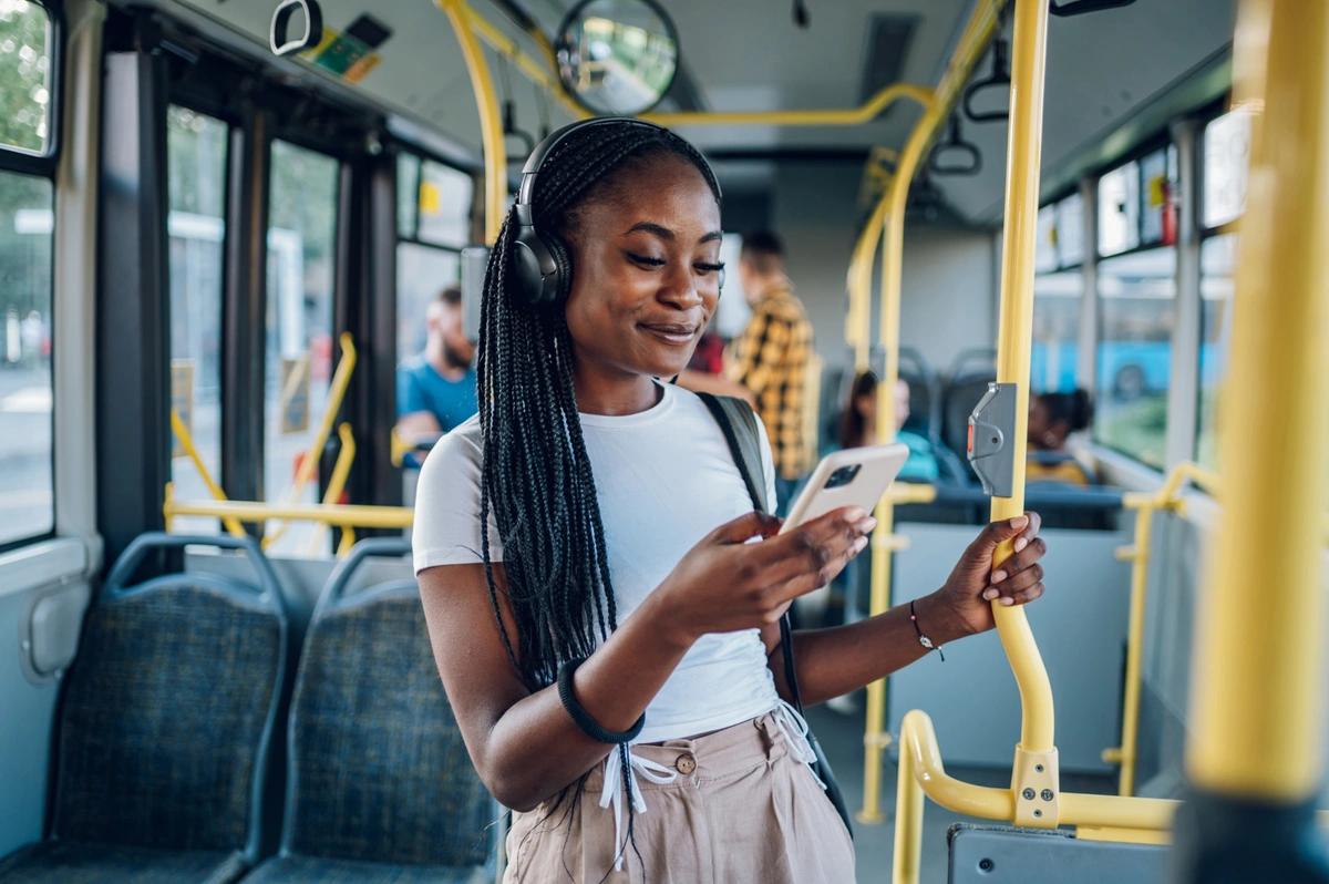 A young woman standing up on a bus