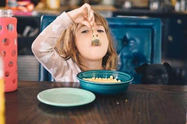 Image of a child eating breakfast cereal in a cafe. New free breakfast club launches for families over the summer holidays. The new Little Loungers Breakfast Club is offering free cereal and milk for children across England and Wales.