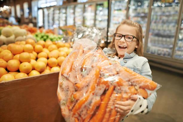 Image of a girl carrying a giant bag of carrots. Why buying in bulk isn't always best .... and other money saving myths