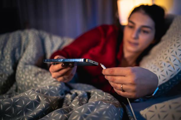 Image of someone putting a mobile phone on charge. Ten surprisingly clever ways to save energy using your home appliances differently (and what you could save)