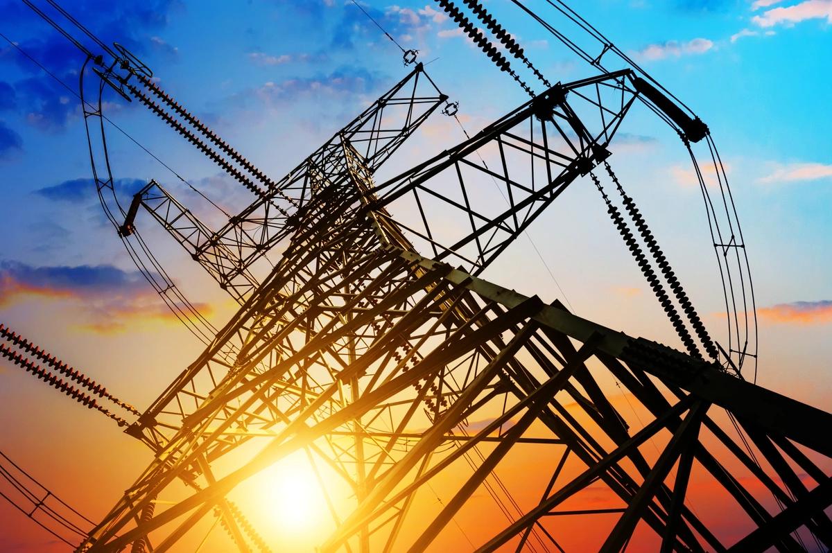 Looking up at an electricity pylon at sunset