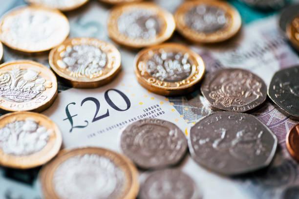 Image of a twenty pound note covered in coins