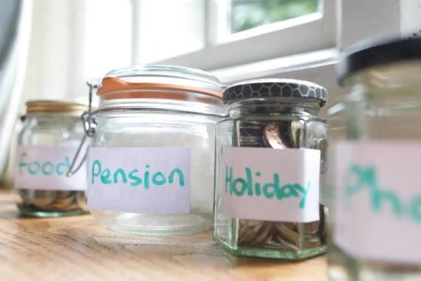 Image of jars with coins in with stickers like phone, pension, holiday etc. 6 things people leave out of their budget - and how to plan for them. From car repairs and vet bills to Christmas and annual payments, here's how to prepare for the costs tha