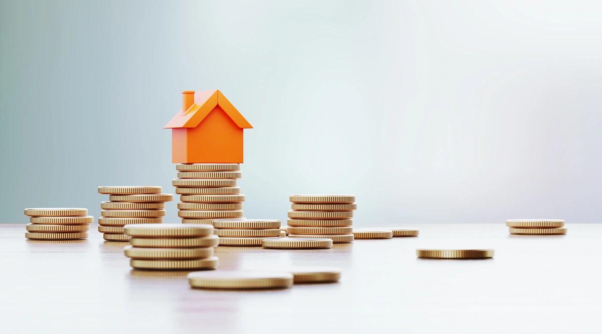 Stacks of coins with a model house sitting on top of one of the stacks