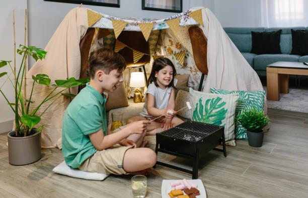 Image of kids playing in a den they have built indoors
