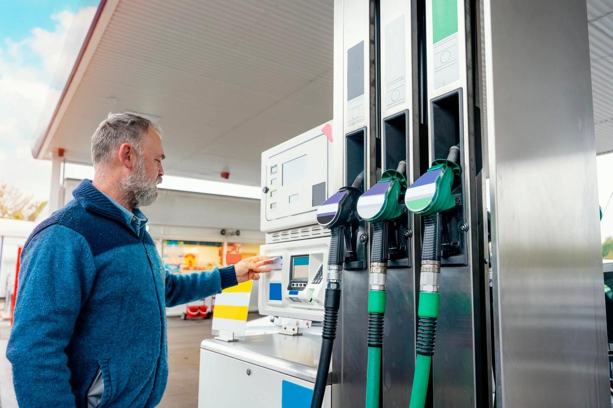 A man enters his card details at a petrol pump