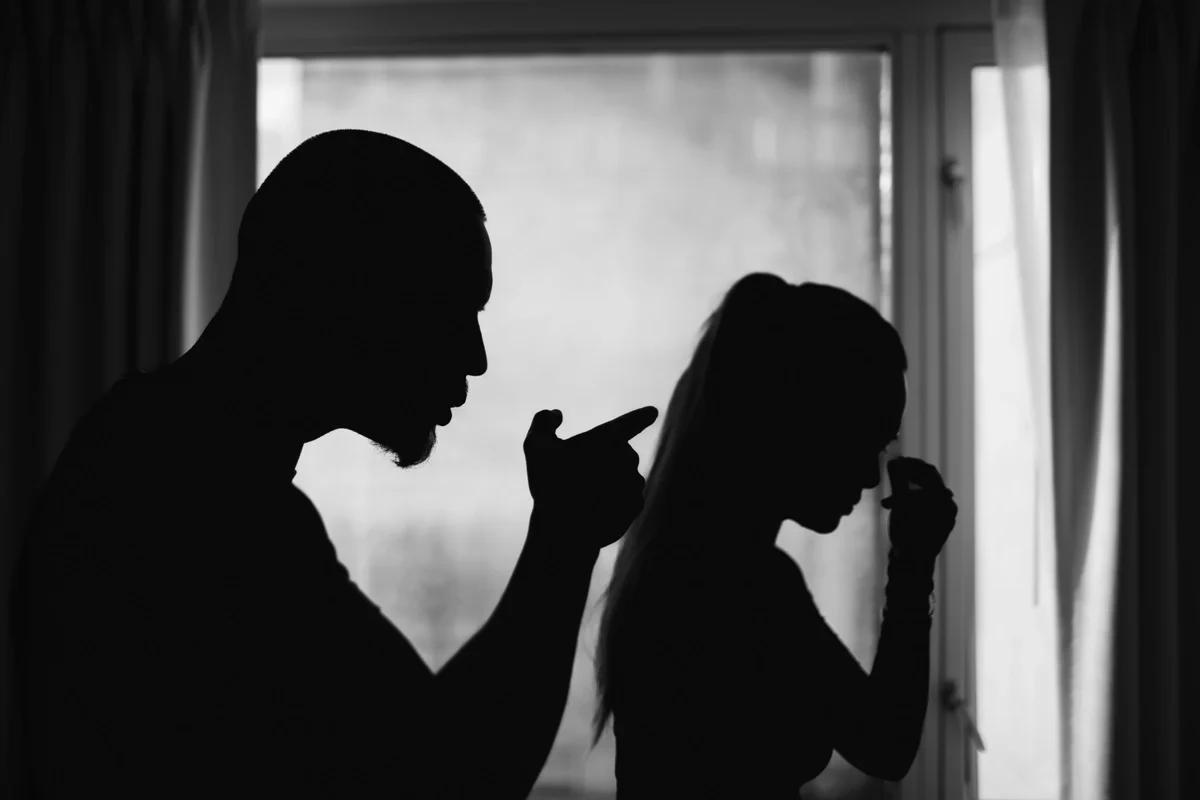The silhouettes of a man shouting at a woman