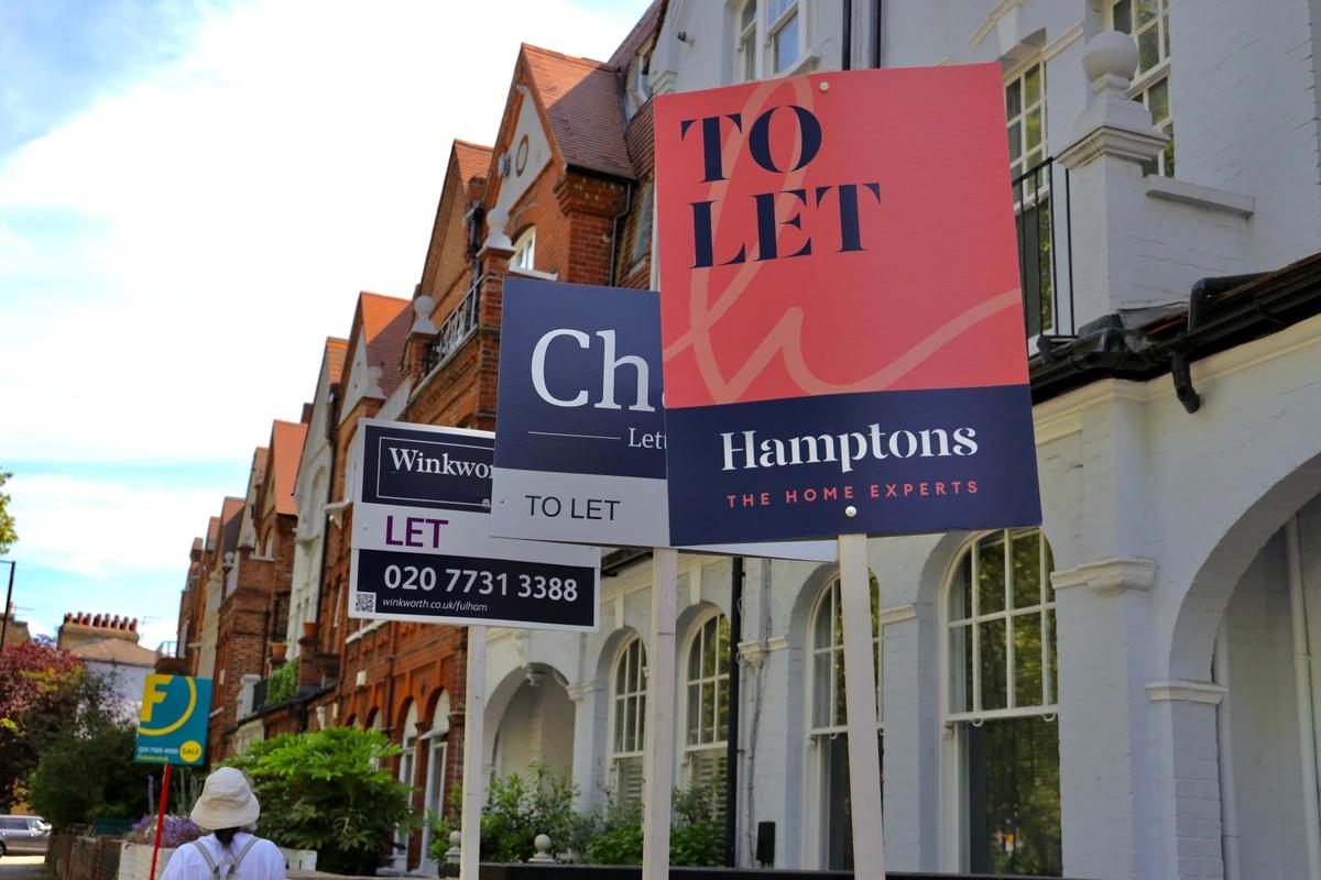 A row of terraced houses with to-let signs outside