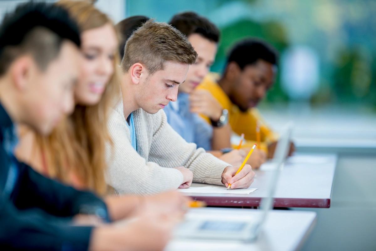 Teenagers studying at desks in a classroom