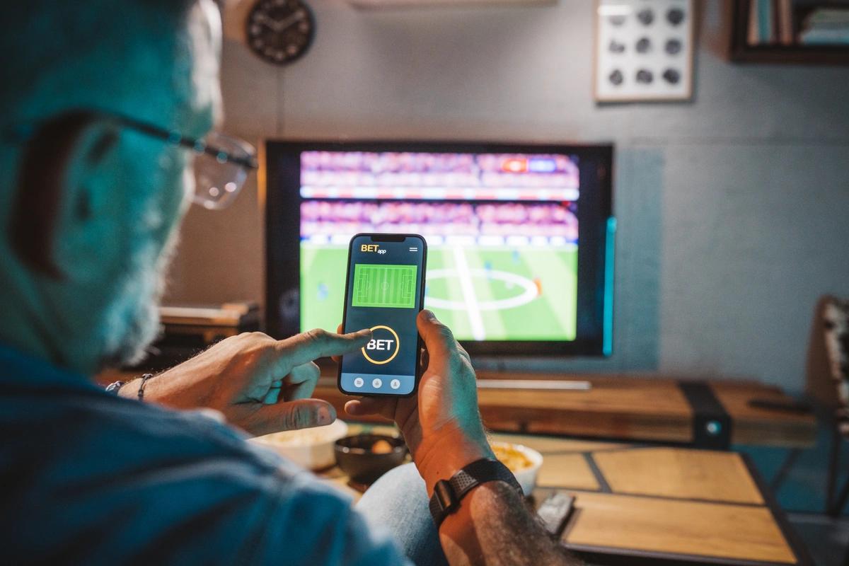 A man places a bet on the football game he's watching on TV