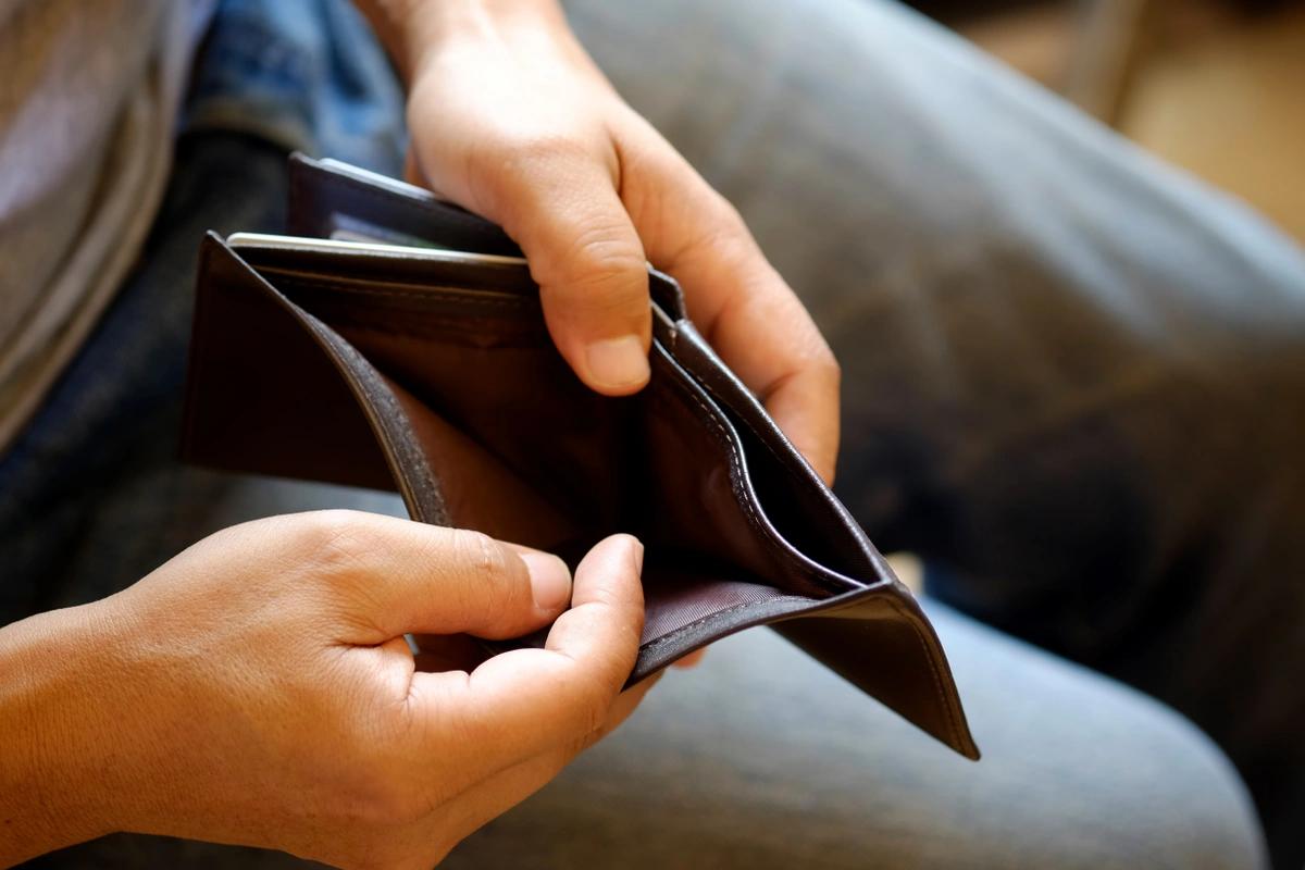 A man looking at his empty wallet