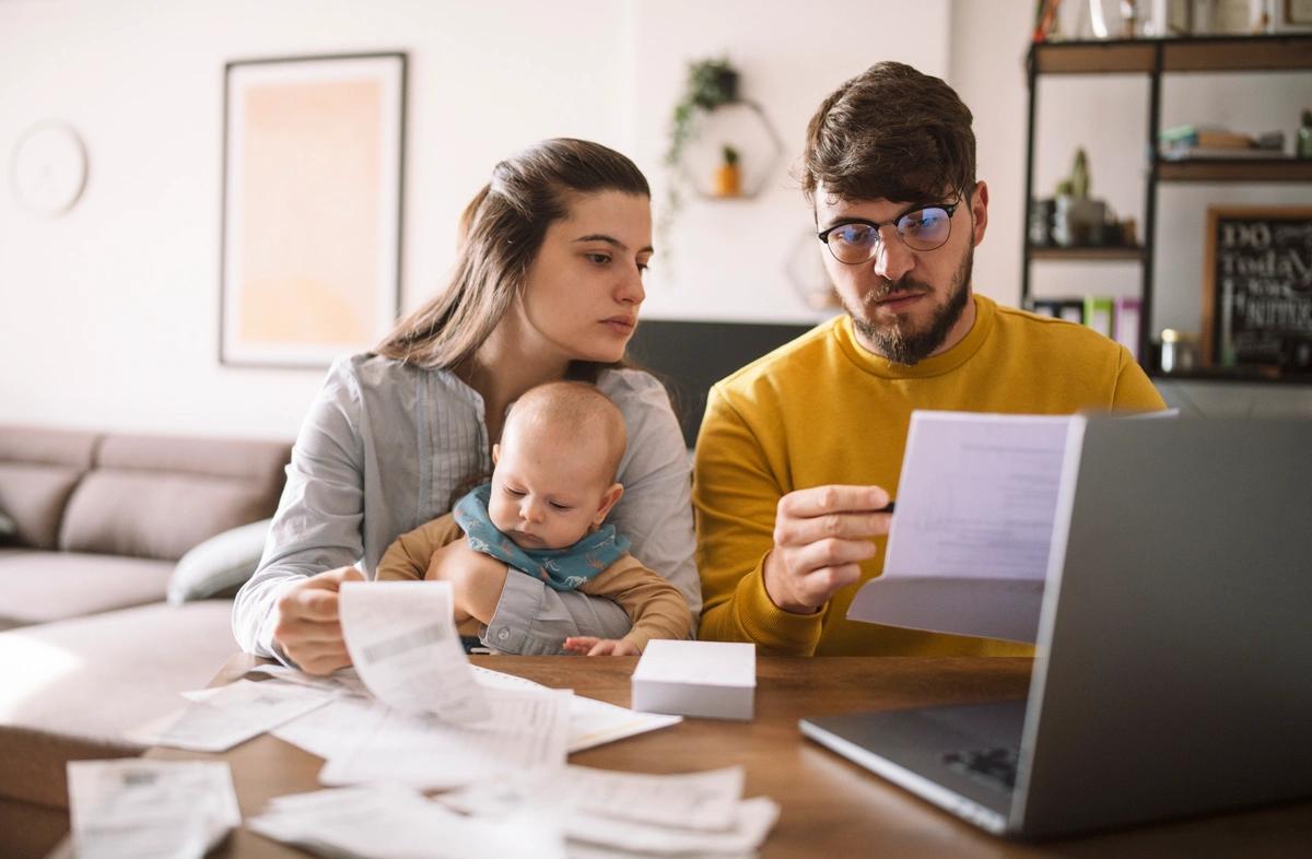 Young couple with a baby go through their bills