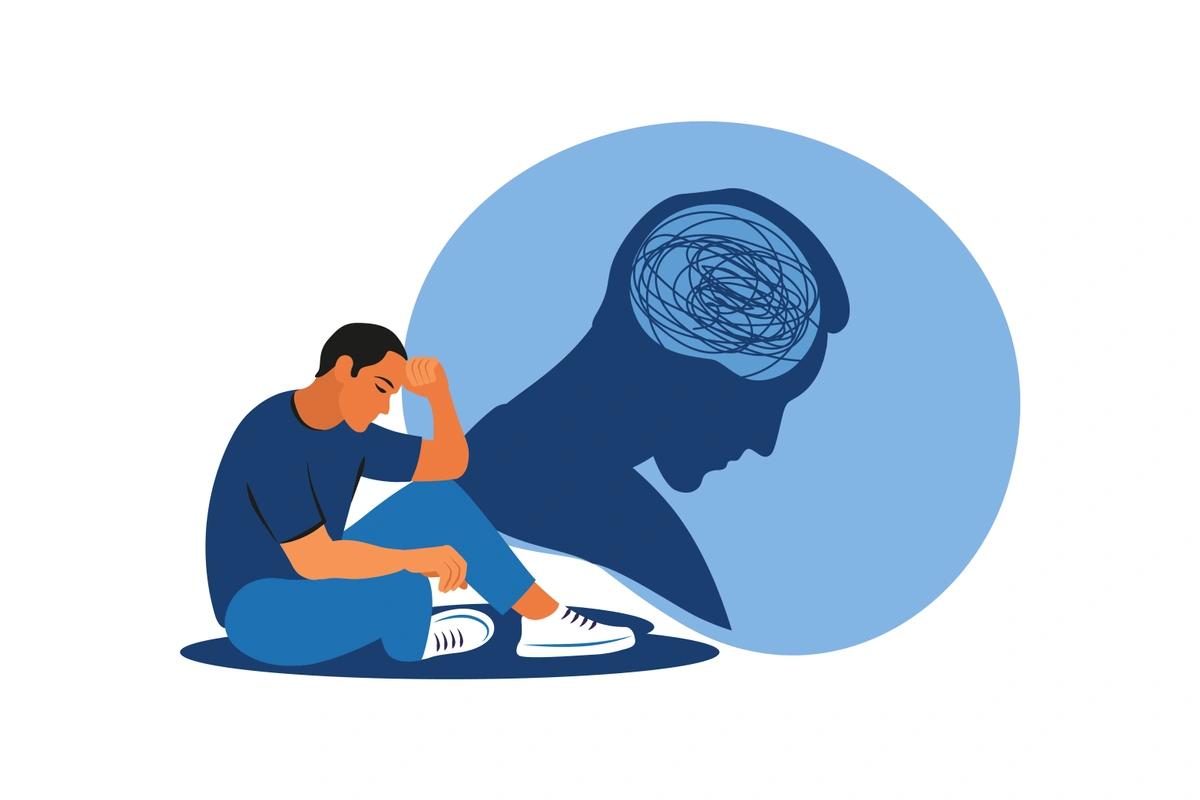 An illustration of a worried man sat with his head in his hands as he sits on the floor.