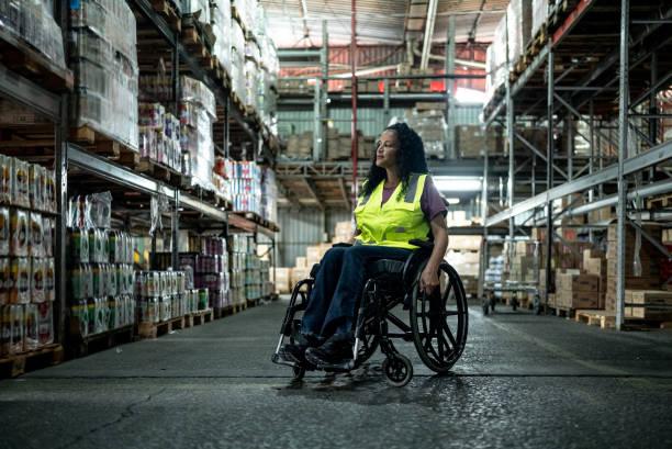 Image of a woman in work in a warehouse who is in a wheelchair. Funding available for those who are disabled and on a low income