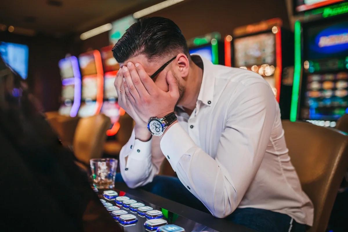 A man with his head in his hands after losing at the fruit machine
