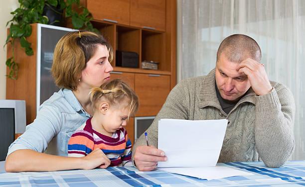 Image of a man, woman and child looking worried about bills