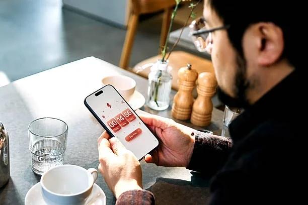 Image of someone looking at their phone with flash sale on it. How Amazon Prime Day and flash sales can blow your budget. Why the biggest shopping events of the year can end up costing you more than you planned