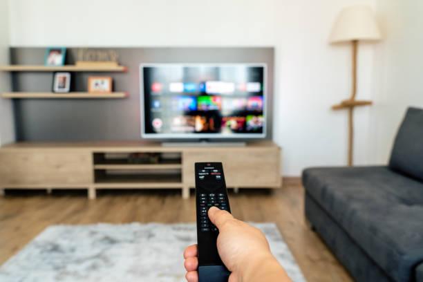 someone holding a remote to a TV