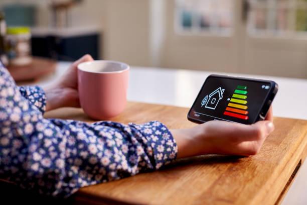 Image of a man holding a smart meter showing how energy efficient his home is