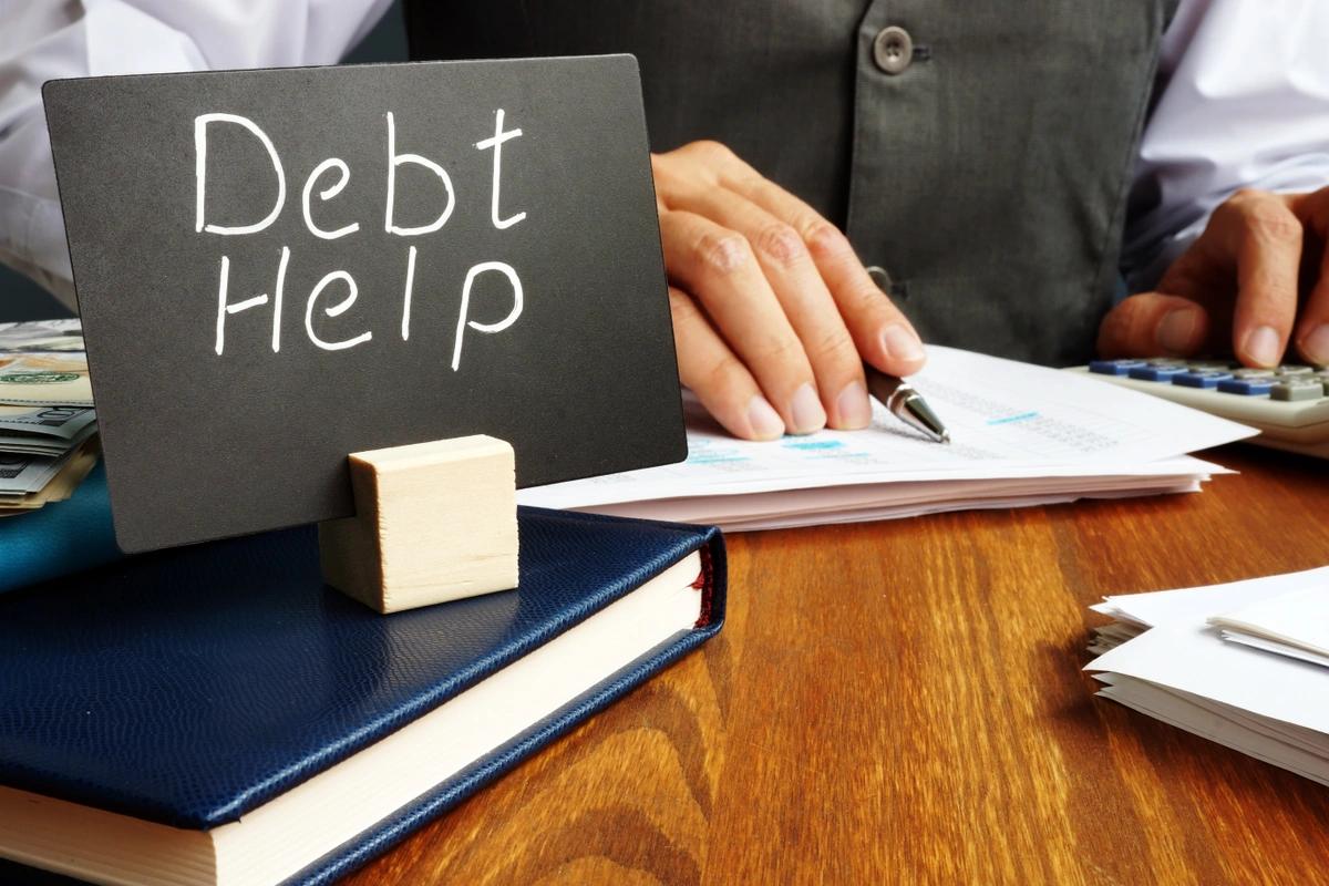 A desk with a debt help sign on it