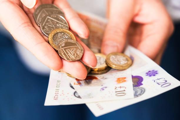 Image of someone counting money. 700,000 people receiving tax credits to get cost of living payment today