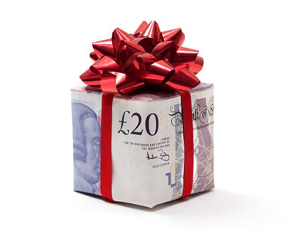 Image of a box wrapped in £20 notes with a red Christmas bow on it