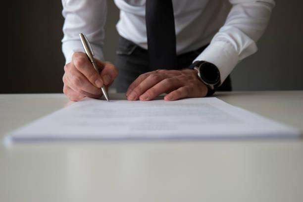 Image of a man signing a financial contract
