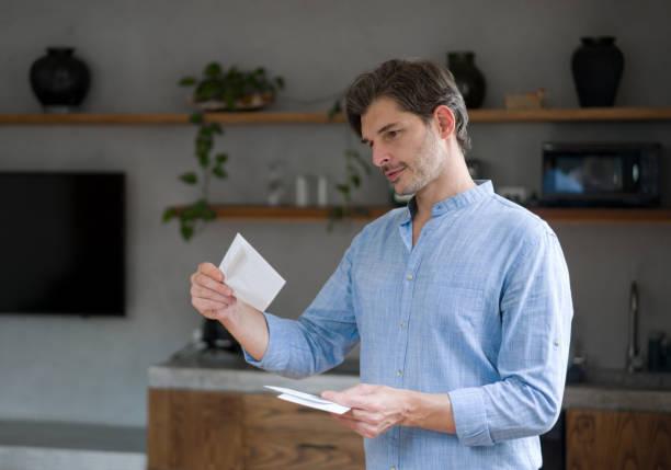Image of a man opening his post with a letter containing a cheque