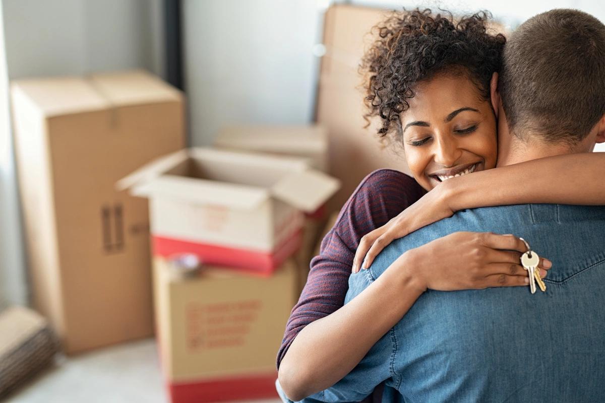 A couple embracing having moved into a new place