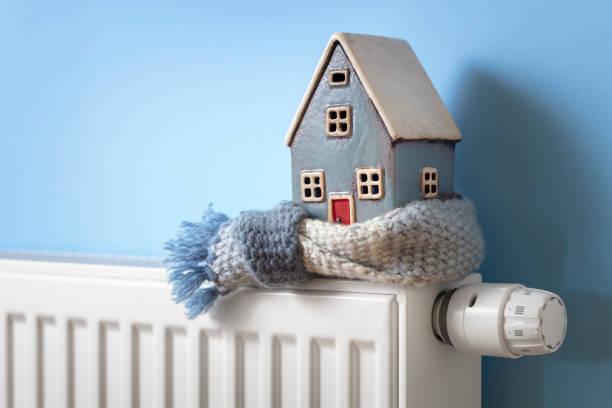 wooden house with a scarf tied around it on top of a radiator