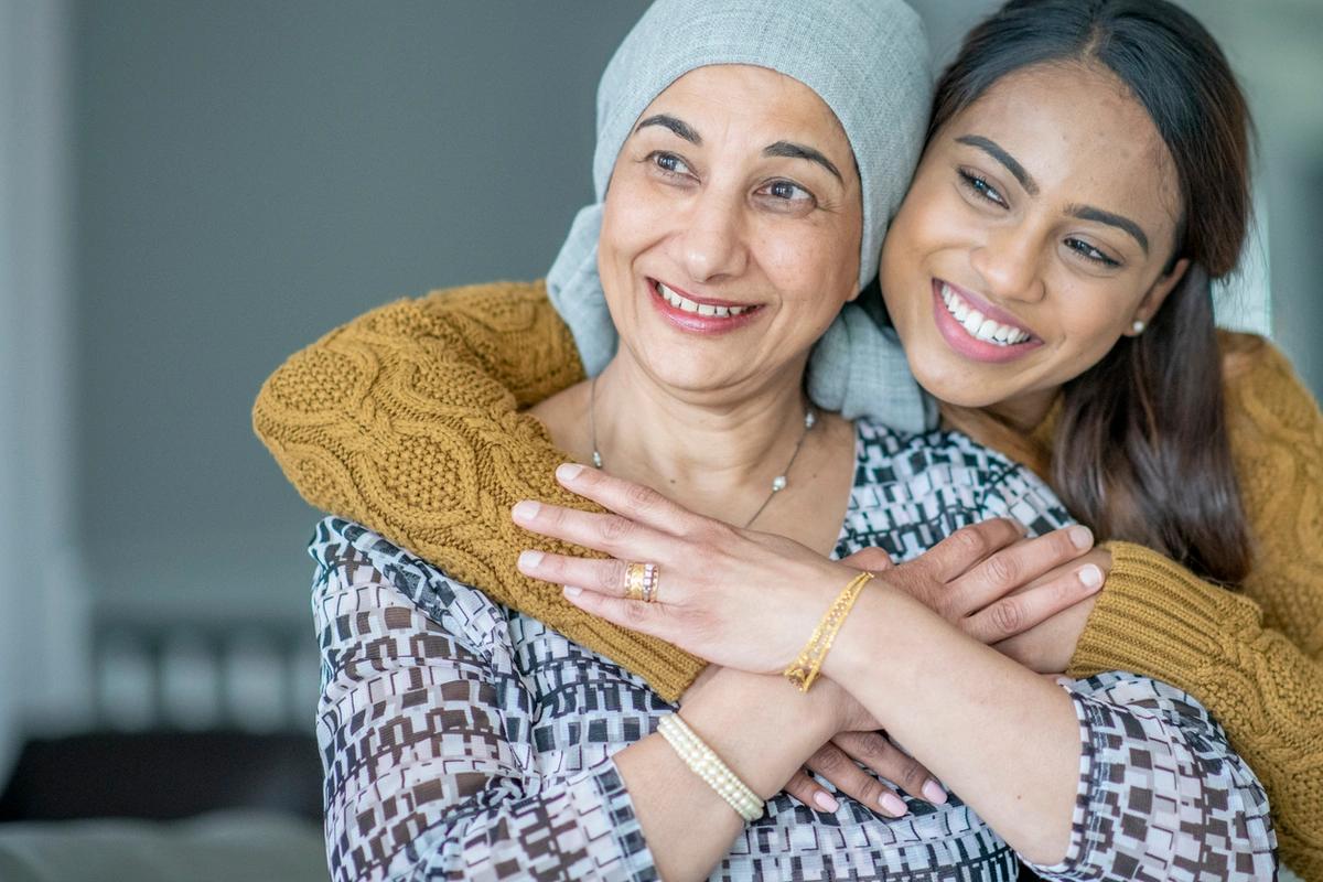 A woman hugs her mother, both are smiling off camera