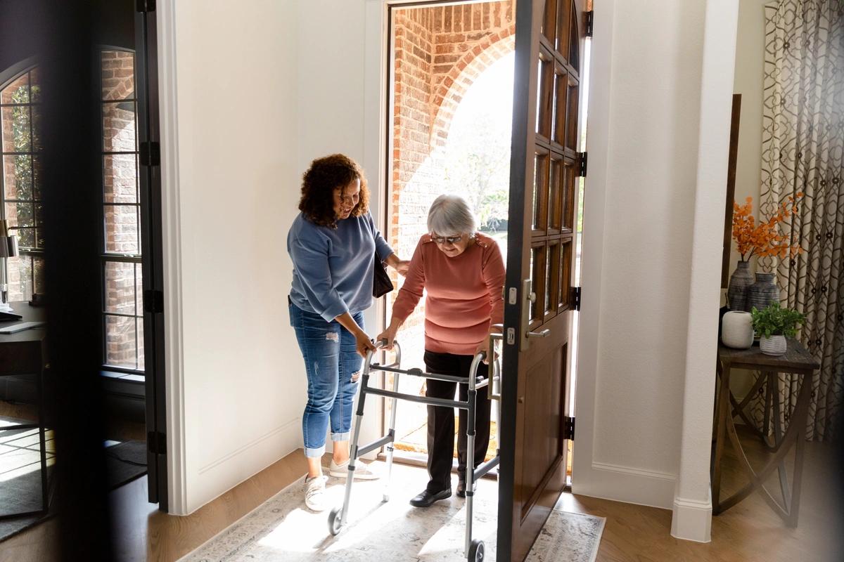 A carer helping an elderly woman