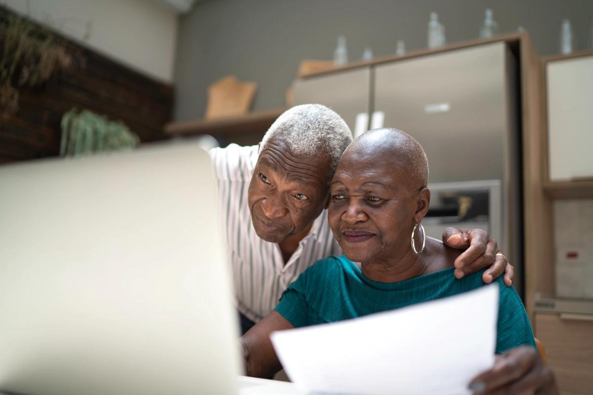 An elderly couple check online to see if the latest cost-of-living payment has landed in their bank account
