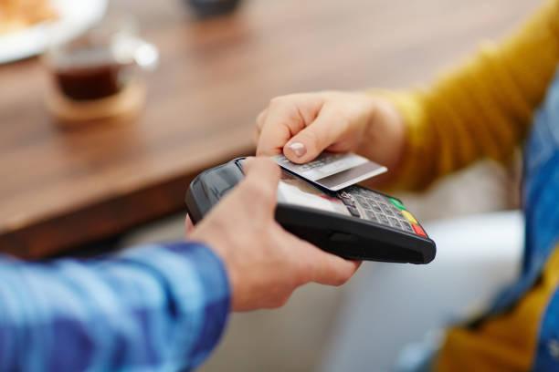 Image of a person paying for goods on a card machine